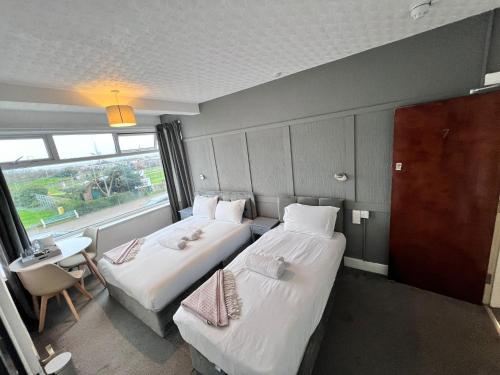 a hotel room with two beds and a window at Harbour Hotel in Skegness