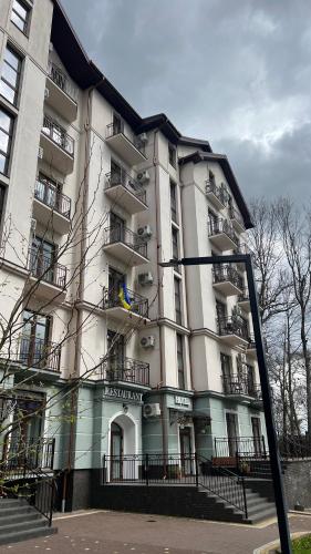un gran edificio blanco con balcones en una calle en Карпати Кайзервальд апарт, en Karpaty