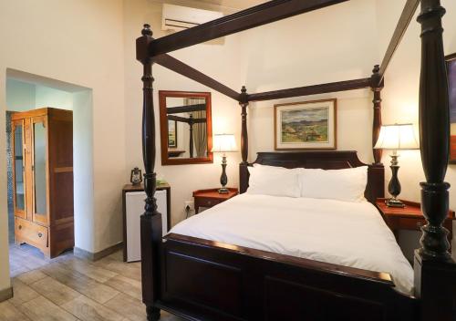 a bedroom with a canopy bed and two lamps at The Victoria House in Ficksburg
