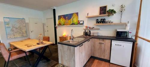 uma cozinha com um lavatório e uma mesa num quarto em Bed&Breakfast Kamersven em Maarheeze