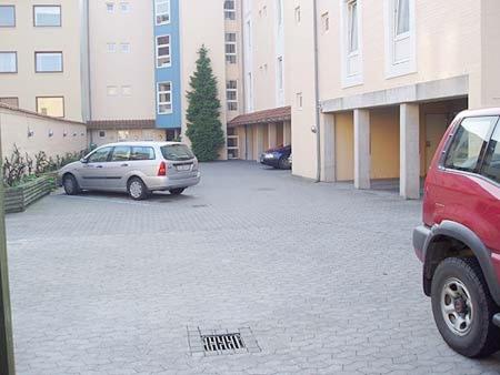 two cars parked in a parking lot next to buildings at City Hotel Nattergalen in Odense