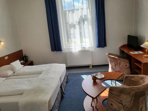 a hotel room with two beds and a table and chairs at Hotel Margit in Trenčianske Teplice