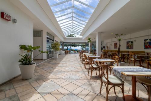a restaurant with tables and chairs and a skylight at Ingleses Praia Hotel in Florianópolis