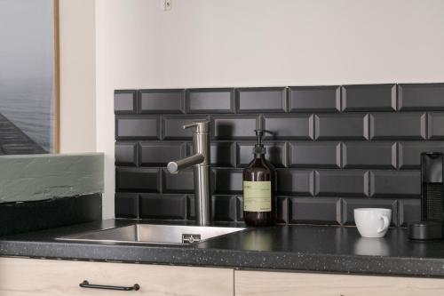 a kitchen counter with a sink and a bottle of wine at The Brewer apartments by Daniel&Jacob's in Copenhagen