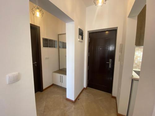 a hallway with a black door and a mirror at Dineta Flat Apartment in Ulcinj