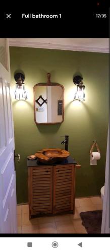 a bathroom with a sink and lights on the wall at Ionian Lefkada Sunset House flyMeRachi40m in Exanthia