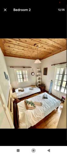 1 dormitorio con 2 camas y 2 ventanas en Ionian Lefkada Sunset House flyMeRachi40m, en Exanthia