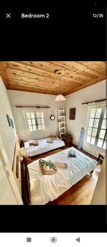a bedroom with two beds and two windows at Ionian Lefkada Sunset House flyMeRachi40m in Exanthia