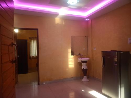 uma casa de banho com WC e luz roxa em Golden villa em Calangute