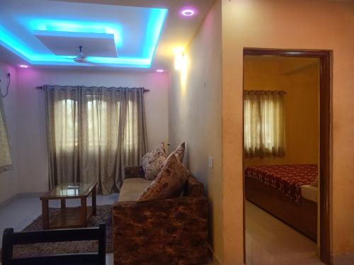 a room with a couch and a bed and a mirror at Golden villa in Calangute