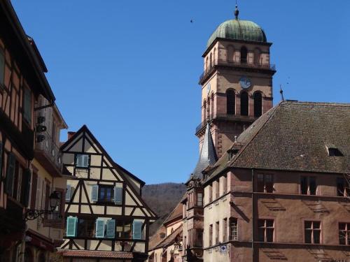 un vecchio edificio con una torre dell'orologio in una città di Origin'alsace a Kaysersberg