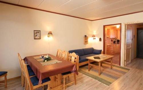 - un salon avec une table et un canapé bleu dans l'établissement Skarslia Apartment, à Skarsgård