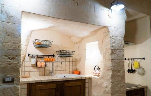 uma cozinha com um lavatório e uma parede de pedra em More Apartments The Castle em Bari