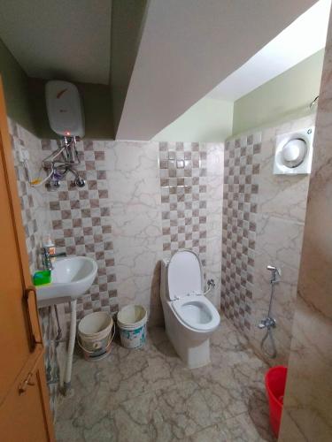 uma casa de banho com um WC e um lavatório em The Guest House em Patna