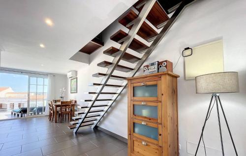 a spiral staircase in a living room with a table at Dúplex Fornells Carme 3 in Fornells