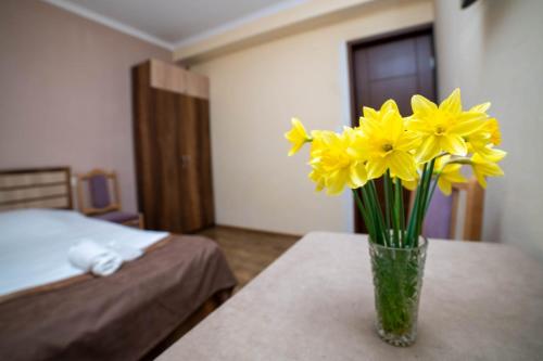 a vase filled with yellow flowers sitting on a table at Guest House Kavkasioni 33 in Telavi