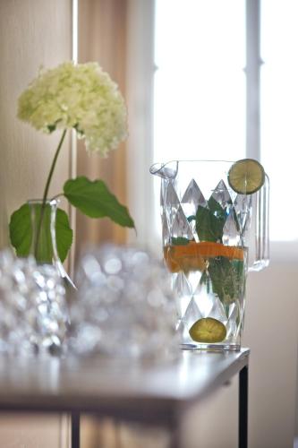 a table with a glass vase with flowers and a vase at Der Charlottenhof in Ahrenshoop