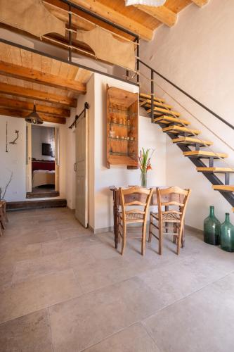 a dining room with a table and chairs and a staircase at Casale Millinchè in Scicli