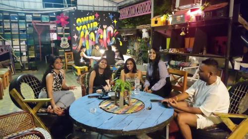 un grupo de personas sentadas alrededor de una mesa en un restaurante en Xhostel Cochin, en Kochi