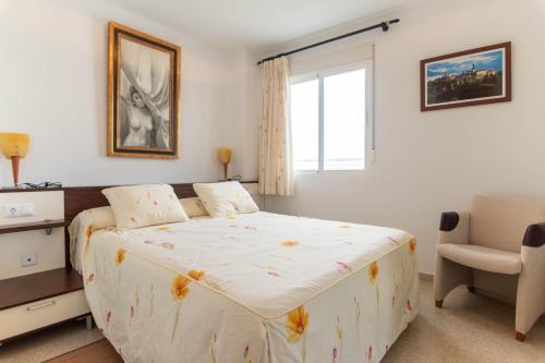 een slaapkamer met een bed, een stoel en een raam bij Vistas del Mar Oasis in El Campello