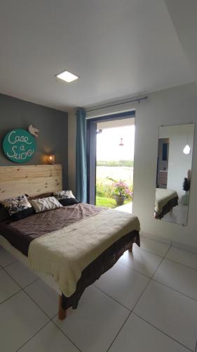 Un dormitorio con una cama grande y una ventana grande. en case à sucre, en Les Trois-Îlets