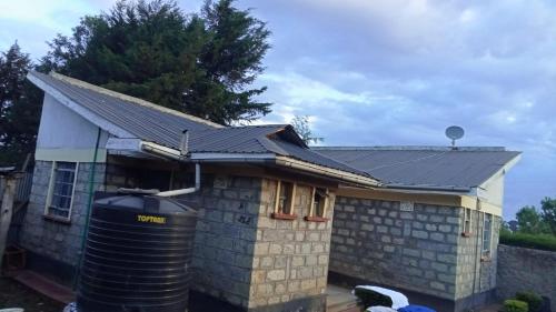 a house with a metal roof and a trash can at FAVOURED EVAMAX in Eldoret