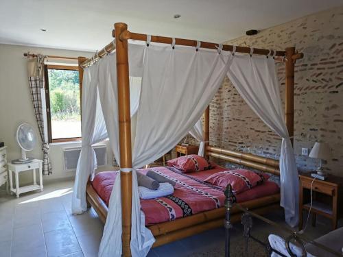 a bedroom with a canopy bed in a room at CHAMBRE ROMANTIQUE in Mur-de-Sologne