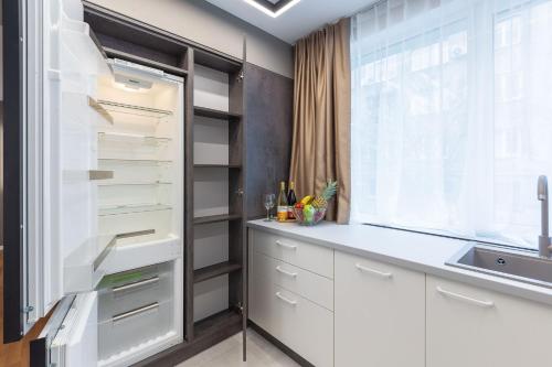 a kitchen with white cabinets and a refrigerator at SofiaStayApartments A11 in Sofia
