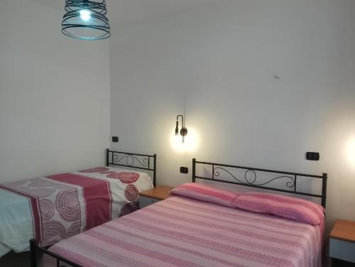 um quarto com 2 camas e um candeeiro em Giallo Sole em Colleferro