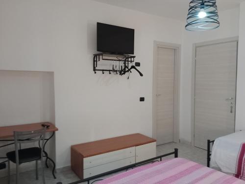 a bedroom with a bed and a desk and a tv on the wall at Giallo Sole in Colleferro