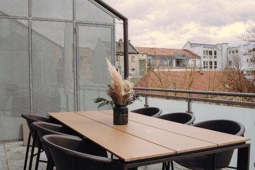 y balcón con mesa y sillas de madera. en 21rooms, en Ingolstadt