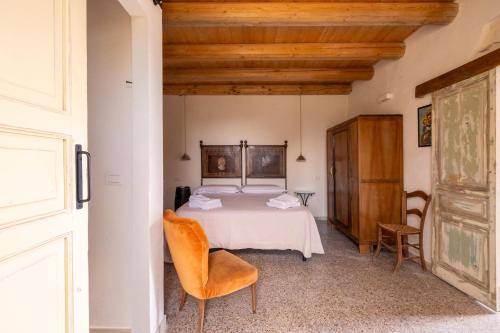 a bedroom with a bed and a table and chairs at Casale Millinchè in Scicli