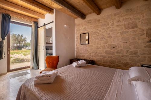 a bedroom with a large bed and a stone wall at Casale Millinchè in Scicli