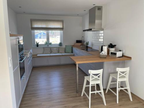 a kitchen with a counter and two stools at Haus Hyggelig direkt am Großen Zechliner See in Rheinsberg