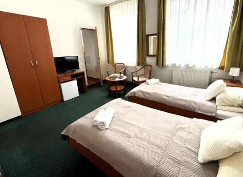 a hotel room with two beds and a television at Broadway City Guesthouse in Budapest