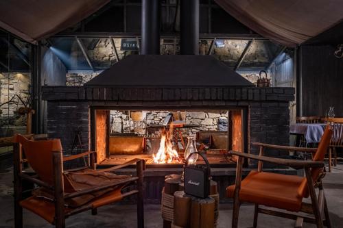 a brick fireplace with a fire in it at BZIKA Hilltop Tent Hotel in Zhangjiajie