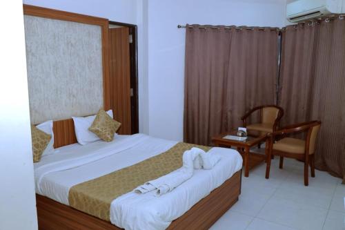 1 dormitorio con 2 camas, escritorio y silla en Kings Resort, en Silvassa