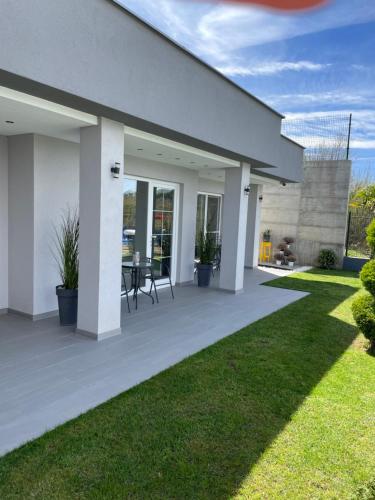 a white house with a patio and grass at Villa Dimo Topal in Ohrid