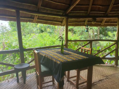 a table and chairs on the porch of a house at Pumba Safari Cottages in Busonga
