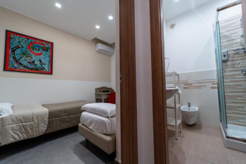 Habitación con 2 camas y baño con ducha. en Alta Dimora, en Bitritto