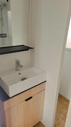 une salle de bain avec un lavabo blanc et un miroir dans l'établissement Superbe mobile home neuf - Mazet 71 - Camping la Carabasse, à Vias