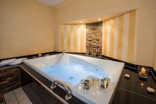 a large bath tub with two wine glasses in it at Hotel Pergola im Göbels Hotel Rodenberg in Rotenburg an der Fulda