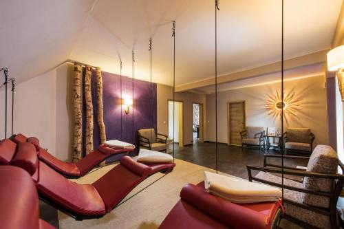 a living room with red chairs and a mirror at Gästehaus Pergola in Rotenburg an der Fulda