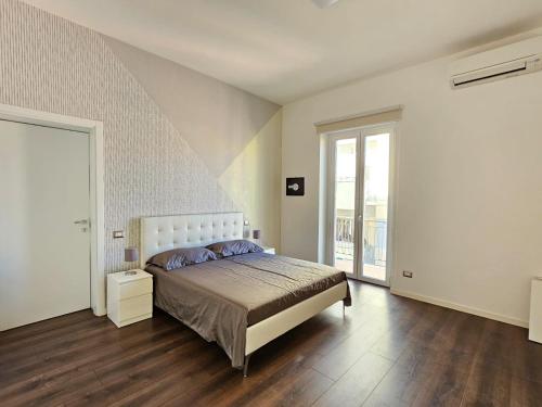 - une chambre avec un lit et une grande fenêtre dans l'établissement Maison Silvana, Luxury Apartment, à Salerne