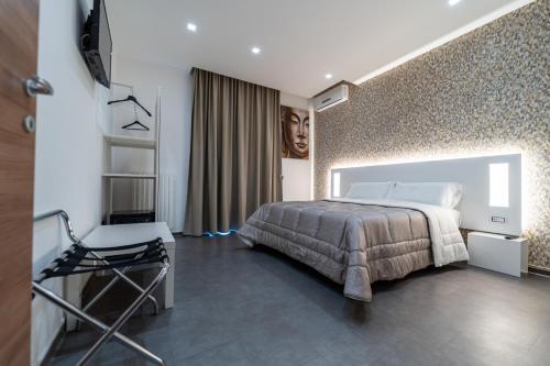 a bedroom with a bed and a chair in it at Alta Dimora in Bitritto