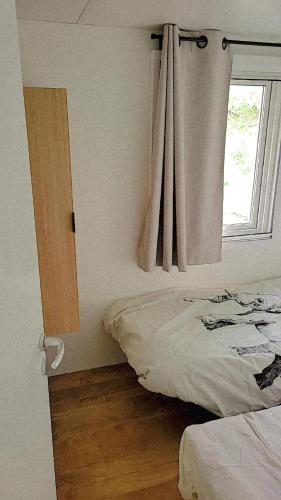 une chambre avec un lit et une fenêtre dans l'établissement Superbe mobile home neuf - Mazet 71 - Camping la Carabasse, à Vias
