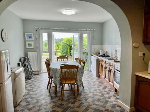 cocina con mesa y sillas y cocina con arco en Moville Beach Townhouse on Wild Atlantic Way, en Moville