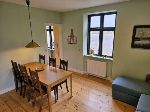a living room with a table and chairs and a couch at Privat lejlighed på landejendommen Frederiks-Eg in Herlufmagle