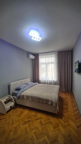 - une chambre avec un grand lit et une fenêtre dans l'établissement Irina apartament Stefan 64, à Chişinău
