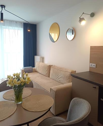 - un salon avec un canapé et une table dans l'établissement NOWY Apartament Bitwy Warszawskiej, à Siedlce